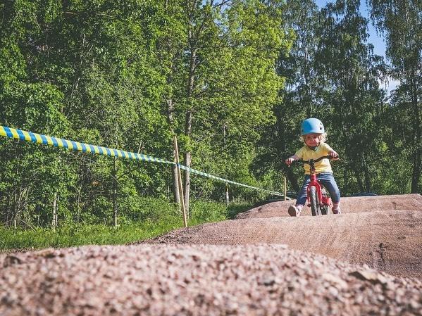 toddler on her balance bike riding a dusty pump track from instagram@elnadahlstrand